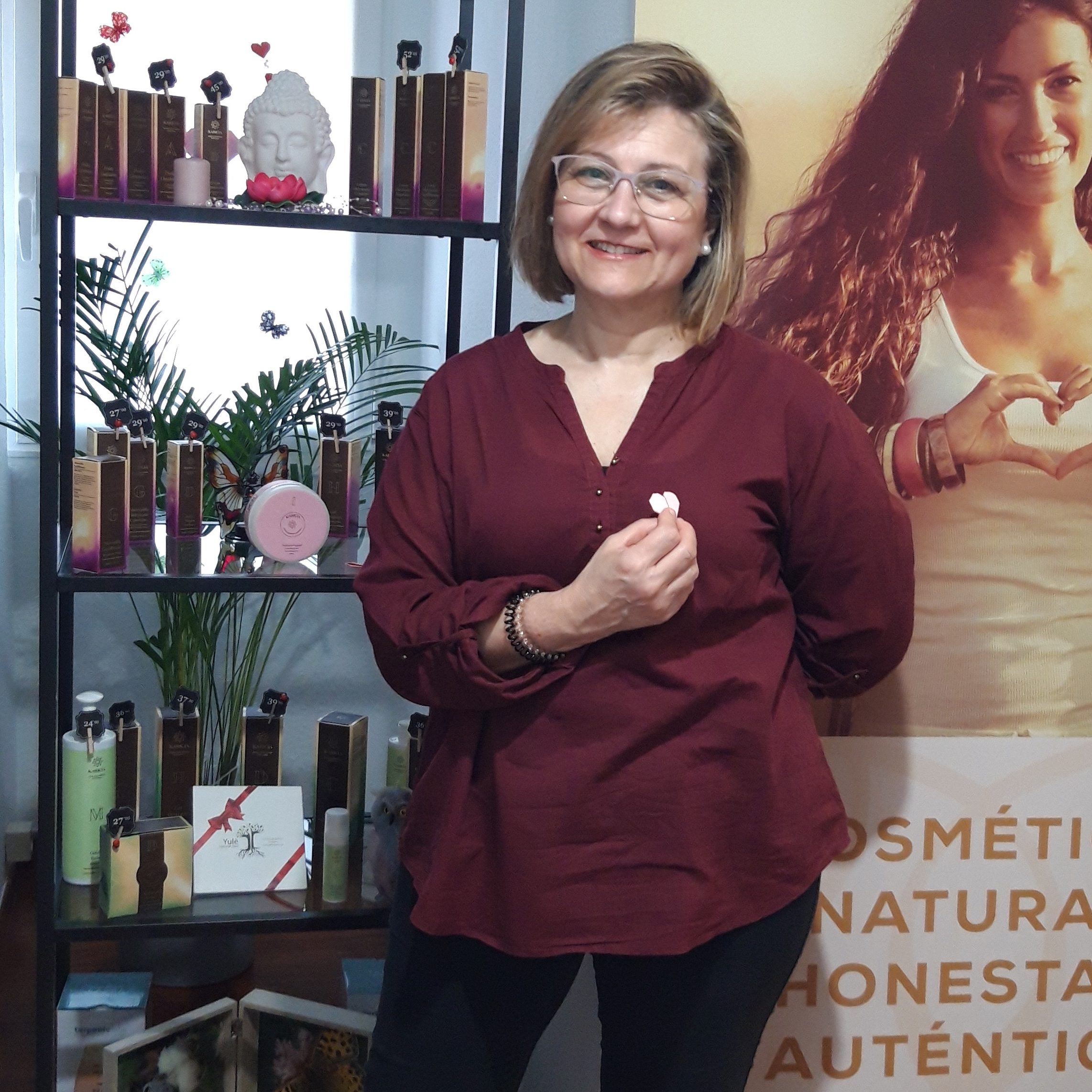 Mujer de centro estetico sonriendo en frente de productos karicia
